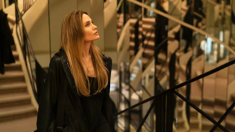 Angelina Jolie dans le film Coutures, marchant dans un décor élégant pendant la Fashion Week parisienne.