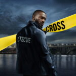 Alex Cross interprété par Aldis Hodge dans la série Cross sur Prime Video, devant un pont nocturne avec ruban jaune d’enquête