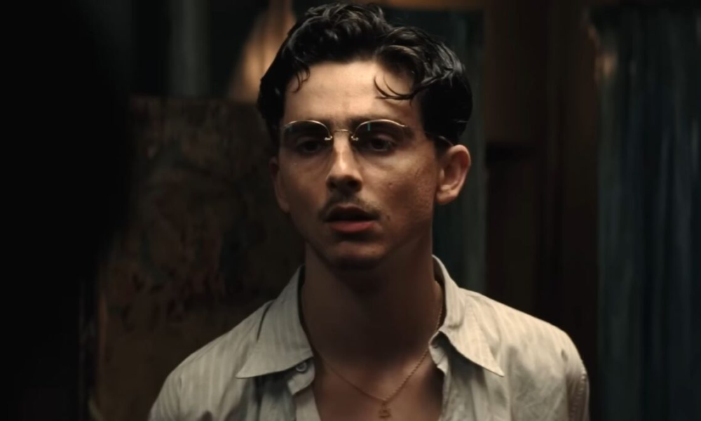 Timothée Chalamet moustache fine et lunettes rondes dans le film Marty Supreme réalisé par Josh Safdie.