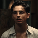 Timothée Chalamet moustache fine et lunettes rondes dans le film Marty Supreme réalisé par Josh Safdie.