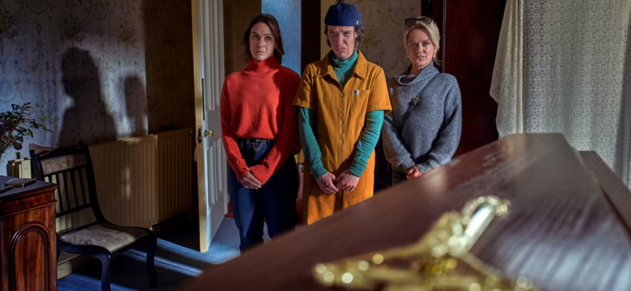 Saoirse, Robyn et Dara devant le cercueil dans De Belfast au paradis sur Netflix