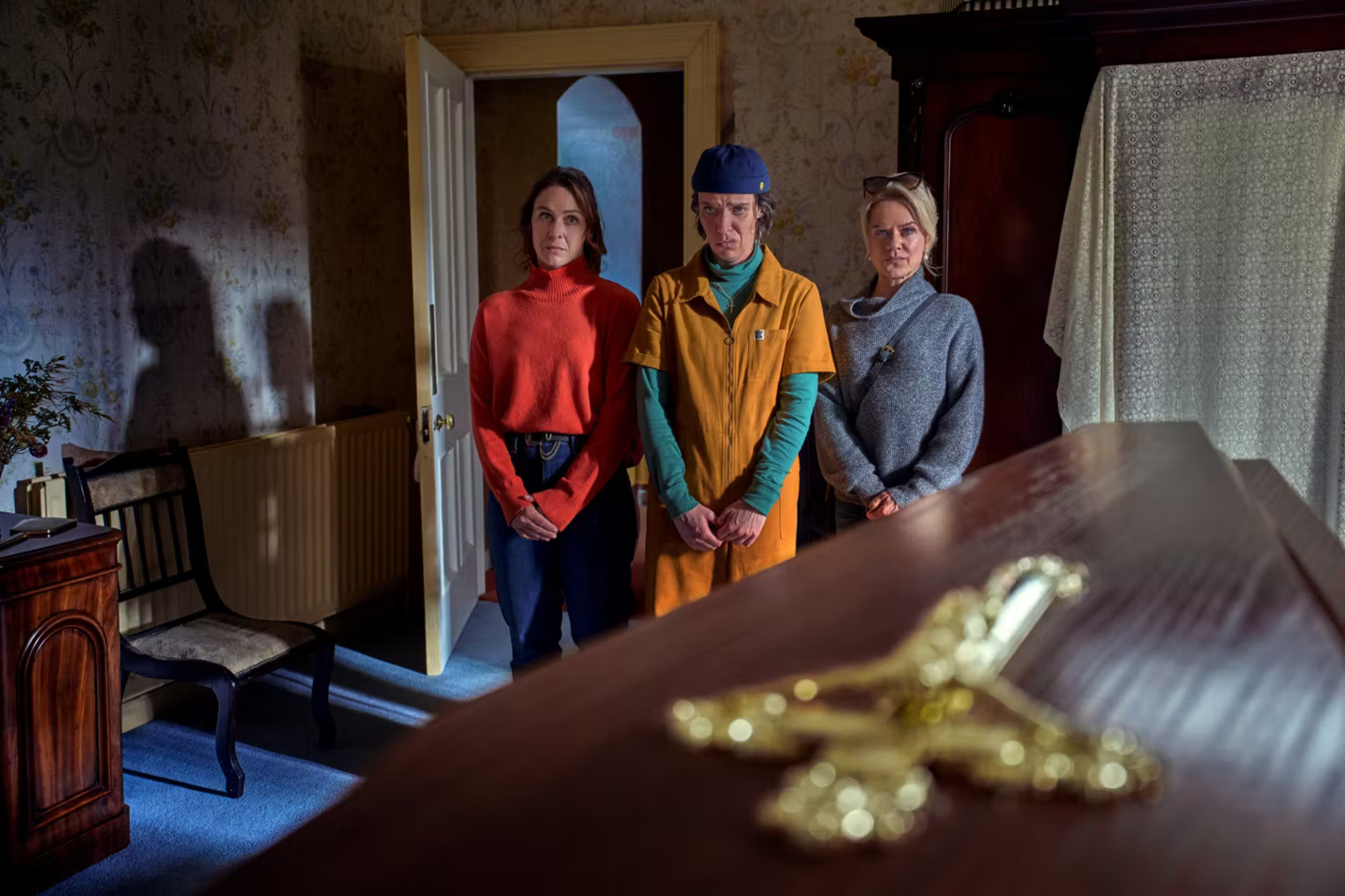 Saoirse, Robyn et Dara devant le cercueil dans De Belfast au paradis sur Netflix