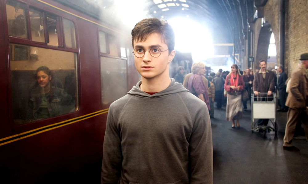 Harry Potter sur le quai 9 3/4 devant le Poudlard Express dans le premier film