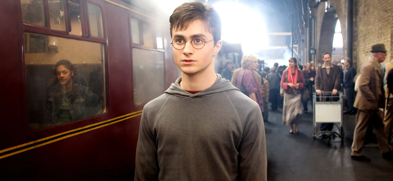 Harry Potter sur le quai 9 3/4 devant le Poudlard Express dans le premier film