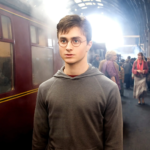 Harry Potter sur le quai 9 3/4 devant le Poudlard Express dans le premier film
