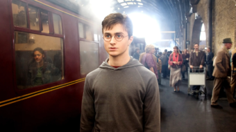 Harry Potter sur le quai 9 3/4 devant le Poudlard Express dans le premier film